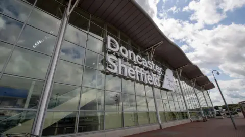 Getty Images A photo of the glass-fronted entrance to Doncaster Airport. No people can be seen in the photo.