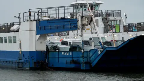 Cars packed into the Torpoint Ferry. It is a large blue and white vessel.