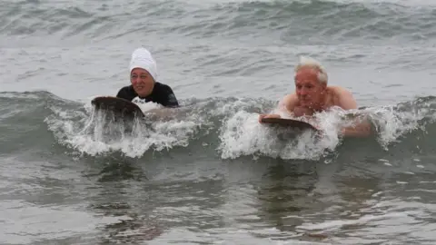 Colin and Doreen on wooden belly boards in the sea