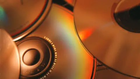 The back of several CD that are spread out.