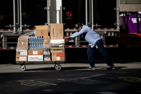 Getty Images A worker pushes pallets of water bottles and other items into Madison Square Garden on Thursday.