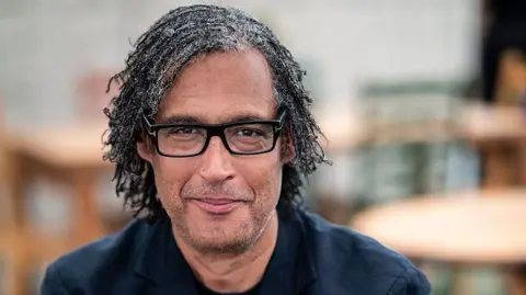 Getty David Olusoga mira a la cámara sonriendo