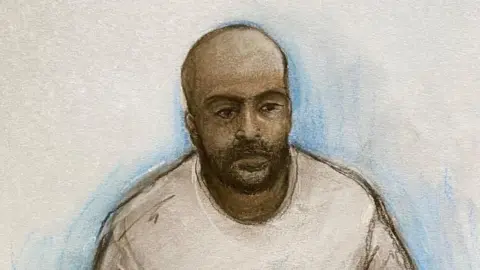Elizabeth Cook/PA Wire Court artist drawing by Elizabeth Cook of Sudanese national Hadi Alodid, 30 appearing via videolink at Belfast Magistrates Court. He is depicted as having brown skin, no hair with a dark beard. He is drawn as wearing a white top and the background is plain.