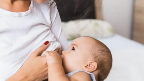 A stock image of a woman breastfeeding a baby