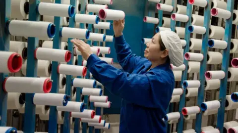 Getty Images shows this image taken on February 22, 2018 a woman working in a textile factory in Hayan in the East Chinese province of Jiangsu.