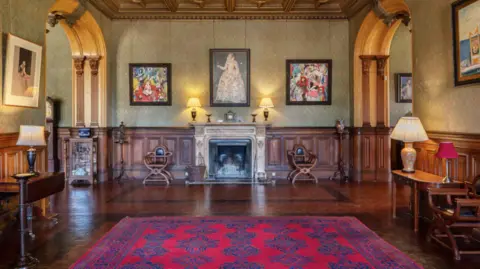 Knight Frank A luxurious room with a large rug and paintings on the wall