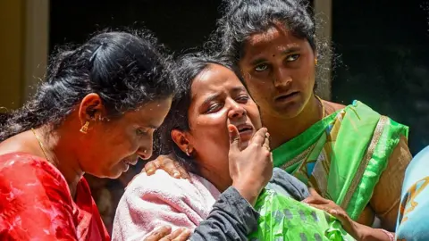 Family members of a victim who died during the stampede outside the M. Chinnaswamy Stadium grieve in front of her body at their residence in the Yelahanka locality in Bengaluru on June 5, 2025. Virat Kohli said he was lost for words after celebrations of a dream IPL title turned to tragedy when 11 mainly young cricket fans were crushed to death in Bengaluru. Hundreds of thousands had packed the streets on June 4 to welcome home their hero Kohli and the Royal Challengers Bengaluru (RCB) after they had beaten Punjab Kings a day earlier in a thrilling Indian Premier League final. (Photo by AFP) (Photo by -/AFP via Getty Images)