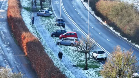 Eddie Mitchell Abandoned cars are visible on roads dusted with snow and ice. 