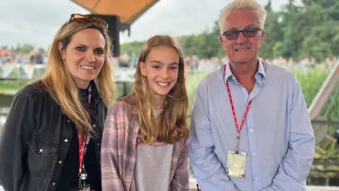 Jon Wright/BBC BBC presenter Sarah Lilley, 2024 poetry winner Anna, and Latitude festival director Melvin Benn on the Waterfront stage at the festival.