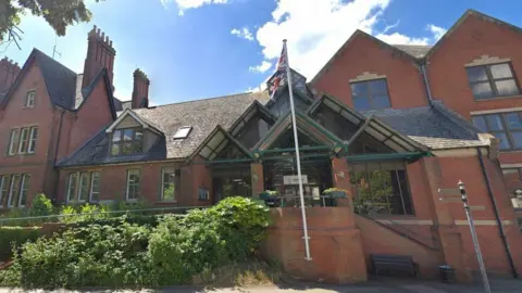 Google Wokingham Borough Council, a red-brick building with a flagpole in front of the main entrance