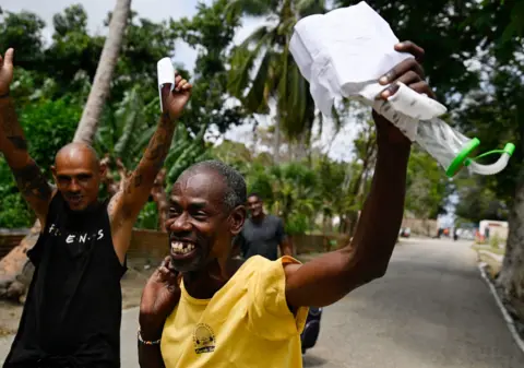 Reuters Released prisoners smile and wave release papers as they leave La Lima prison