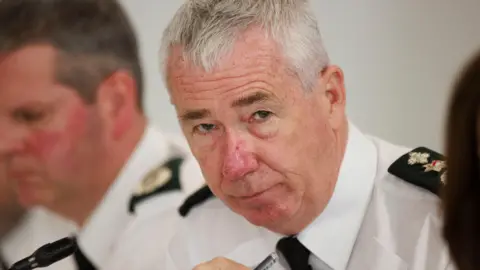 PA Media Jon Boutcher, with grey hair, wearing white shirt and black tie.