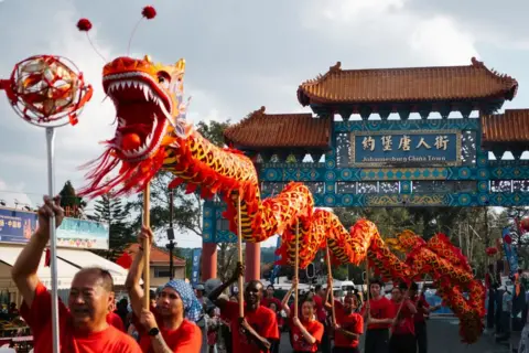 Christian Velcich / AFP A dance troupe holding a float of a dragon weave it through the streets in Johannesburg, South Africa - Saturday 8 February 2025.