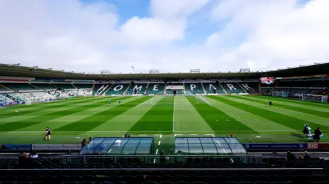 A general view of the stadium at Home Park, Plymouth. The pitch is green. Empty seats surround the stadium. 