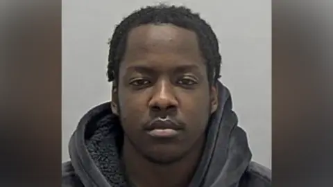 Bedfordshire Police A custody photo shows a young man wearing a dark hoodie