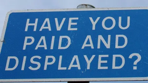 A generic pay and display car park sign. The white writing on a blue background says: "Have you paid and displayed?" 