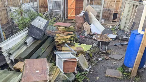 RSPCA Part of an allotment site with discarded items such as broken furniture, rubbish and squalid kennels. 