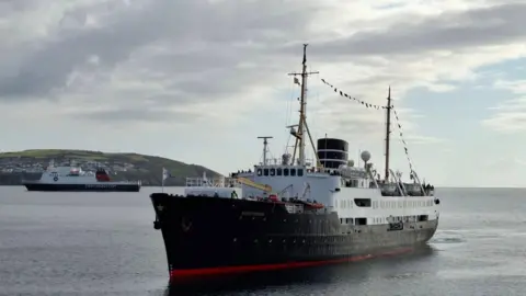 Cruise Ships of the Isle of Man A white, black and red ship sits in Douglas Bay. the ben-ny-Chree ferry is in the background.