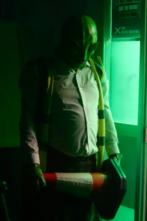 Nathan and Ben McQuaid A green movie alien holding a traffic cone