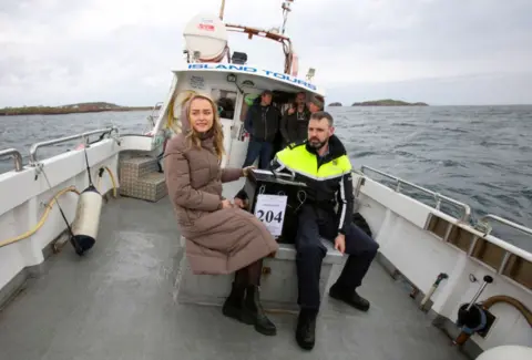 Getty Garda officer and election official pictured at sea on a boat holding ballot box