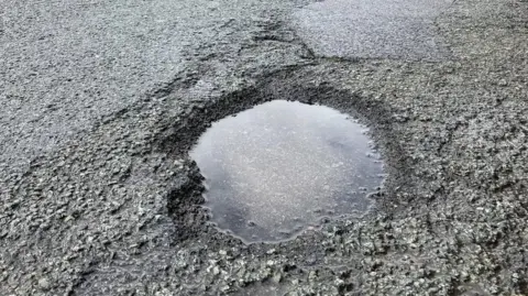A pothole filled with water. 