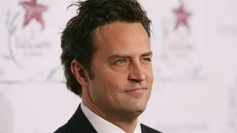 Getty Images Friends star Matthew Perry is seen in a black suit