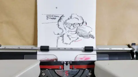 A close-up of a typewriter with a piece of paper in it featuring a portrait of a woman, created using the keys. There is brown paper behind it. 