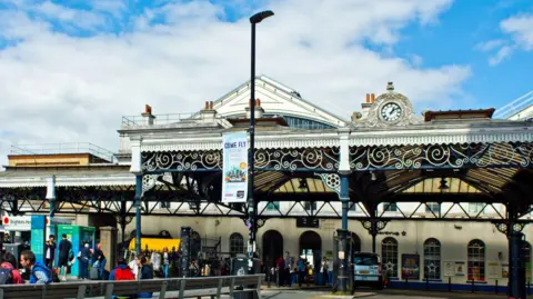 Getty Images The taxi rank outside Brighton train station with passengers moving towards the entrance.