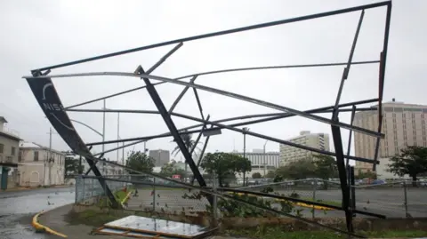 A partially collapsed hoarding frame in Kingston