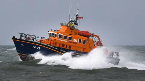 An orange lifeboat in the sea.