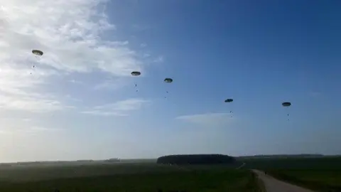 Five parachutes in the sky after the drop. It is clear.