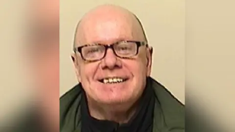 Derbyshire Police Vincent Lee is pictured wearing glasses against a beige background