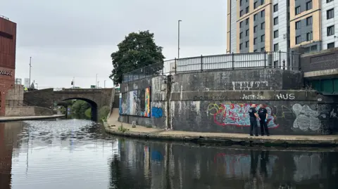 Two officers stood on a canal path near a turning basin