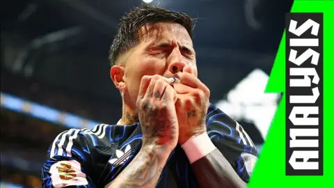 Argentina's Enzo Fernandez kisses his badge after scoring against England