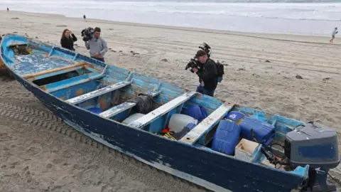 Reuters Members of the media photograph the small boat that capsized off Torrey Pines State Beach