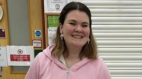 Emily Roberts smiling at a small market where she is selling her marshmallows