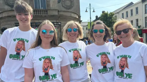 Five people wearing t-shirts that say "G'wan ya girl ye. Hannan Scott"