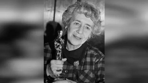 Dame Peggy Ashcroft holding the Academy Award for Best Supporting Actress