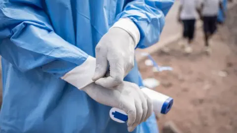 A close-up of a medical staff holding a thermometer 