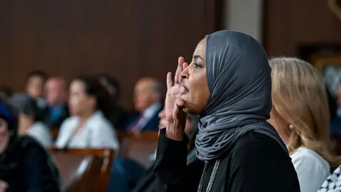 Getty Images Representative Ilhan Omar shouts during a speech by US President Donald Trump