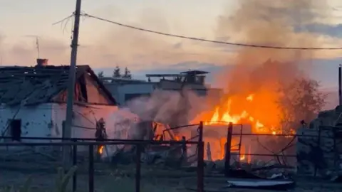     IZ.RU/Reuters Sebuah rumah yang terbakar di kota Sudza, Wilayah Kursk, Rusia barat. Foto: 7 Agustus 2024