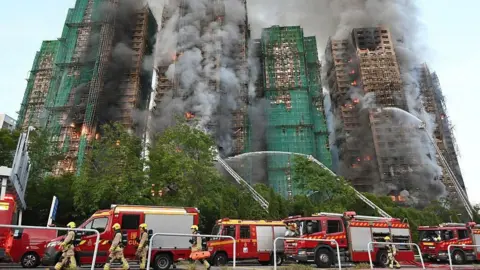 Efforts are underway to extinguish flames as fire engulfs high-rise residential buildings at the Wang Fuk Court complex on November 26, 2025 in Hong Kong, China. 