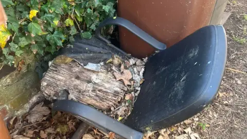 Cait O'Reilly A rotting office chair left in an alley by a bin