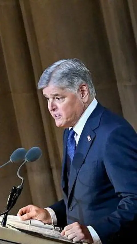 Sean Hannity at a lectern delivering a speech.