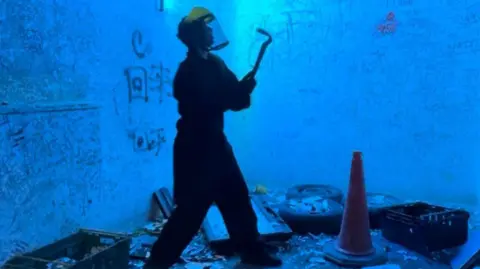 Picture of someone in a rage room surrounded by items to smash