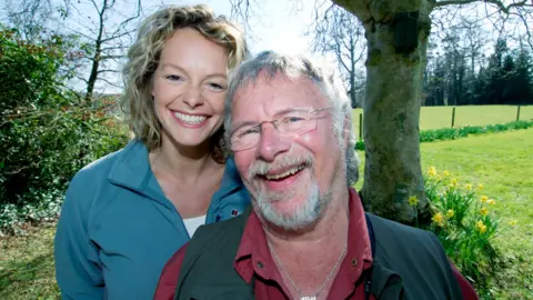 Bill Oddie and Kate Humble standing together and smiling in the countryside