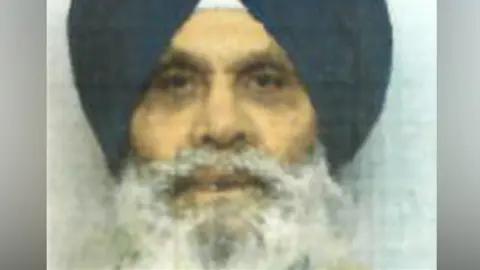 Hertfordshire Constabulary A blurry mugshot photo of Singh Mauji. He is wearing a black turban and has a bushy grey beard and moustache