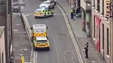 Breaking News and Crime in Edinburgh, The Lothians and Fife An aerial view of The Cowgate shows several police cars and a police van. There is police tape and two police officers standing guard.