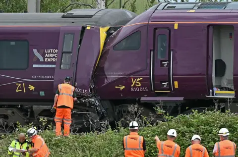 AFP/Getty Images British Transport Police officers, Rail Accident Investigation Branch officers, and Network Rail work at the site of two East Midlands Railway (EMR) trains which crashed into each other.