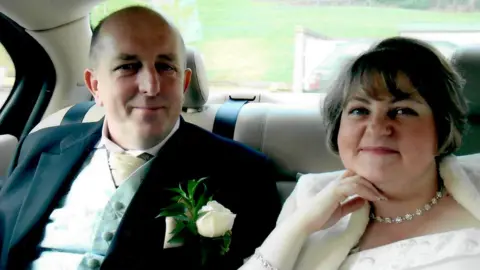 George and Sandra in the back of a car on their wedding day.